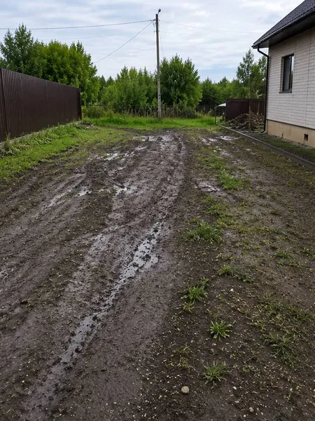 Õu enne töid — roobastes ja läbivettinud maapind maja kõrval